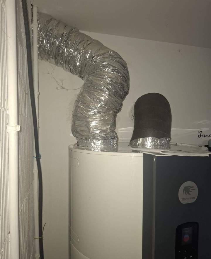 Technicien raccordant un chauffe-eau à gaz  à Bondy